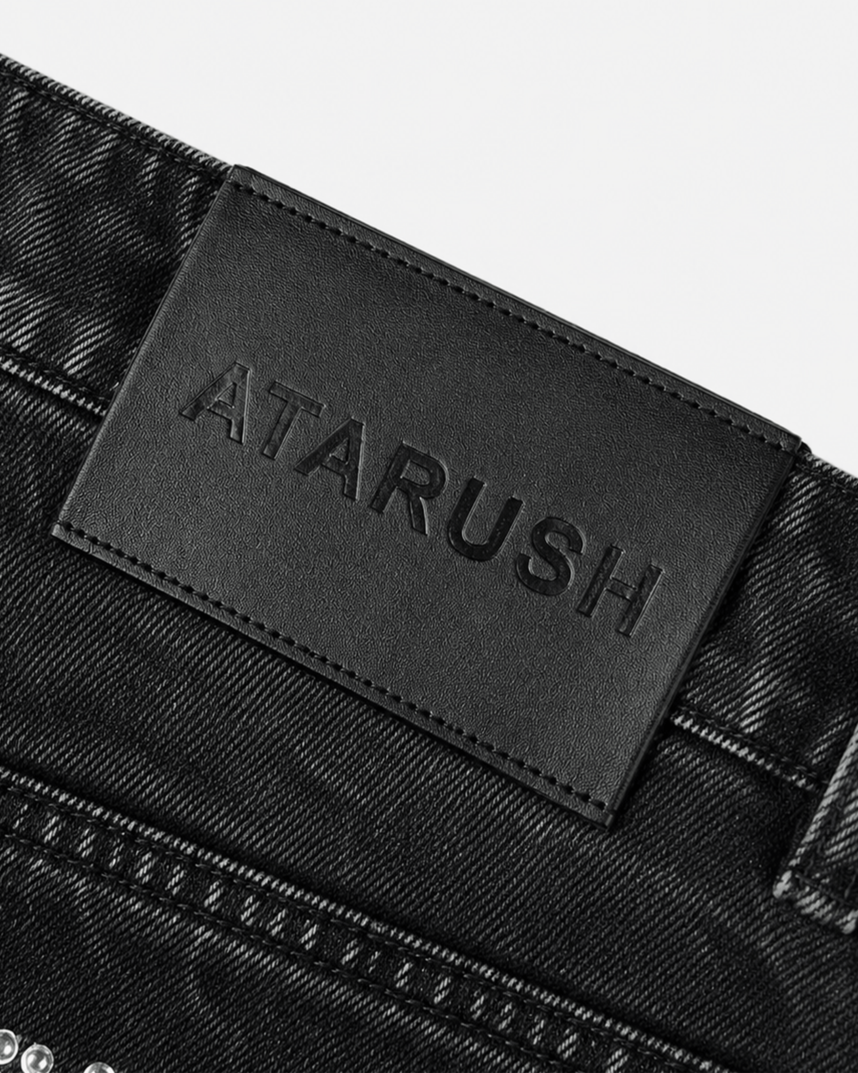 ATARUSH embossed leather patch detail on Compete denim shorts